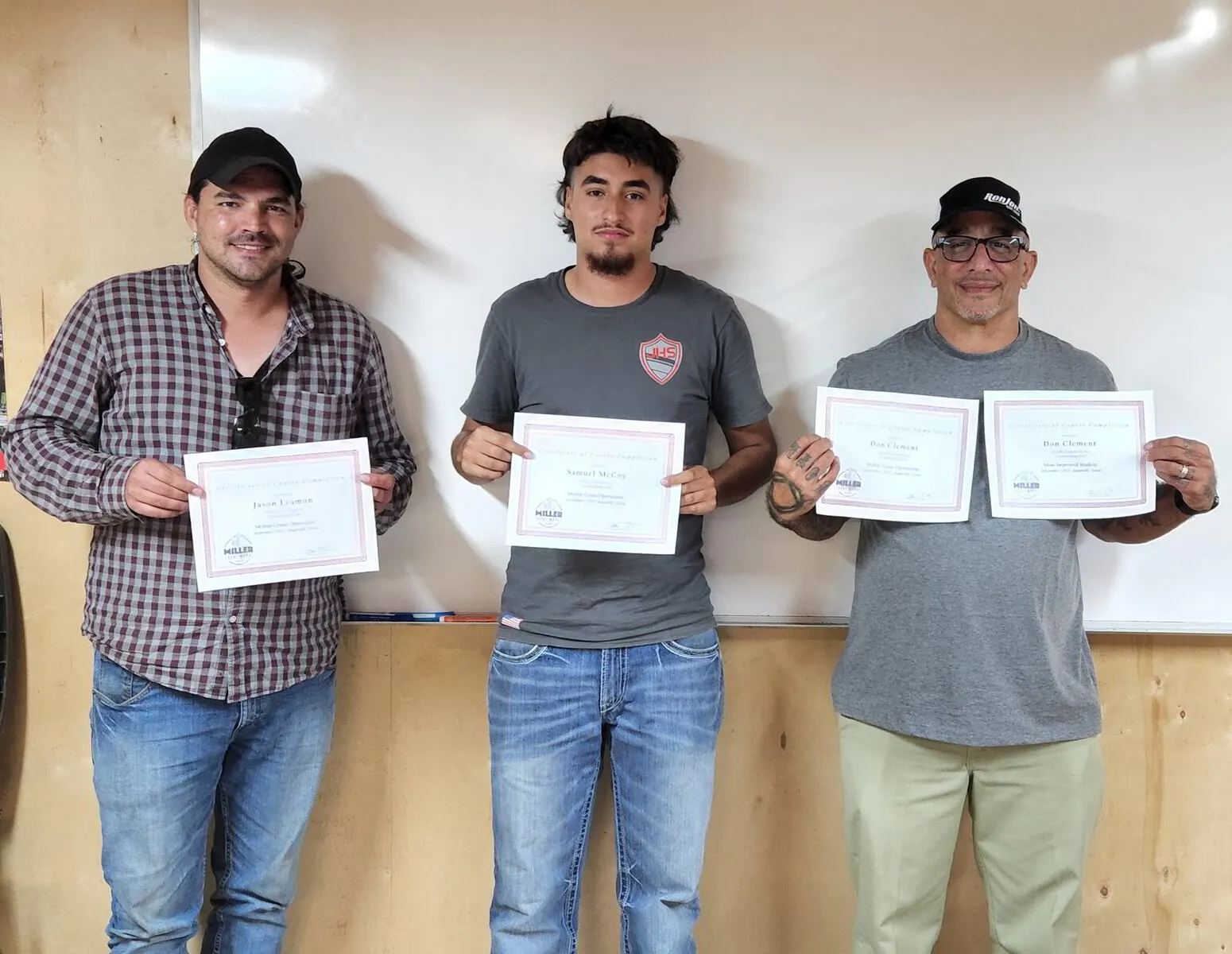 Three Miller Crane Works graduates holding their certificates